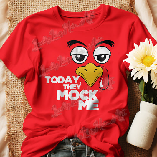 T-shirt with a humorous graphic of a Turkey face and the phrase 'Today They Mock Me' in bold white text. The bird has an expressive face with its tongue out, adding a playful and comedic touch to the design.