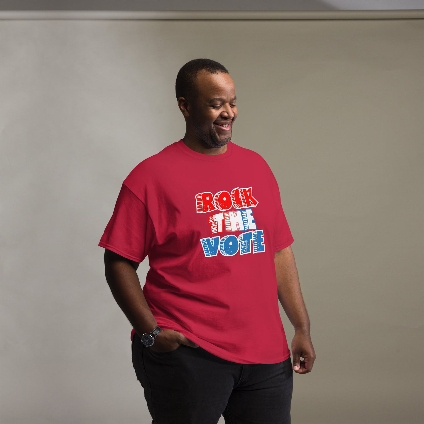 Rock The Vote T-Shirt with bold red, white, and blue lettering inspired by GenX style. The design features a retro, comic-style font with distressed detailing, representing a patriotic election theme. Available in unisex sizes and classic colors, perfect for showing civic pride and encouraging voter participation.