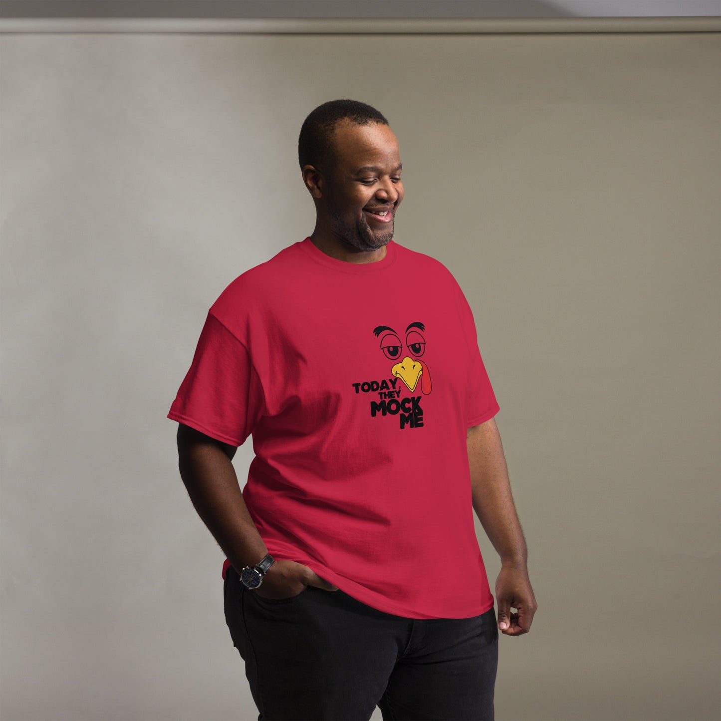 Black t-shirt with a humorous graphic of a mocking bird and the phrase 'Today They Mock Me' in bold white text. The bird has an expressive face with its tongue out, adding a playful and comedic touch to the design.