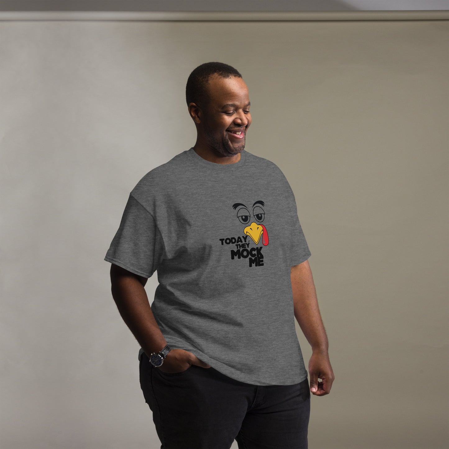 Black t-shirt with a humorous graphic of a mocking bird and the phrase 'Today They Mock Me' in bold white text. The bird has an expressive face with its tongue out, adding a playful and comedic touch to the design.