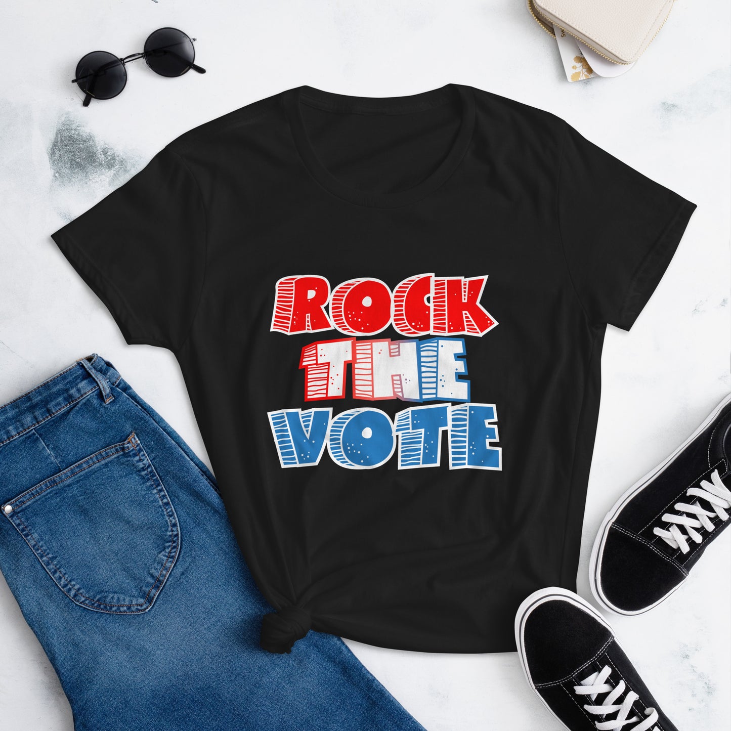 Rock The Vote T-Shirt with bold red, white, and blue lettering inspired by GenX style. The design features a retro, comic-style font with distressed detailing, representing a patriotic election theme. Available in unisex sizes and classic colors, perfect for showing civic pride and encouraging voter participation.