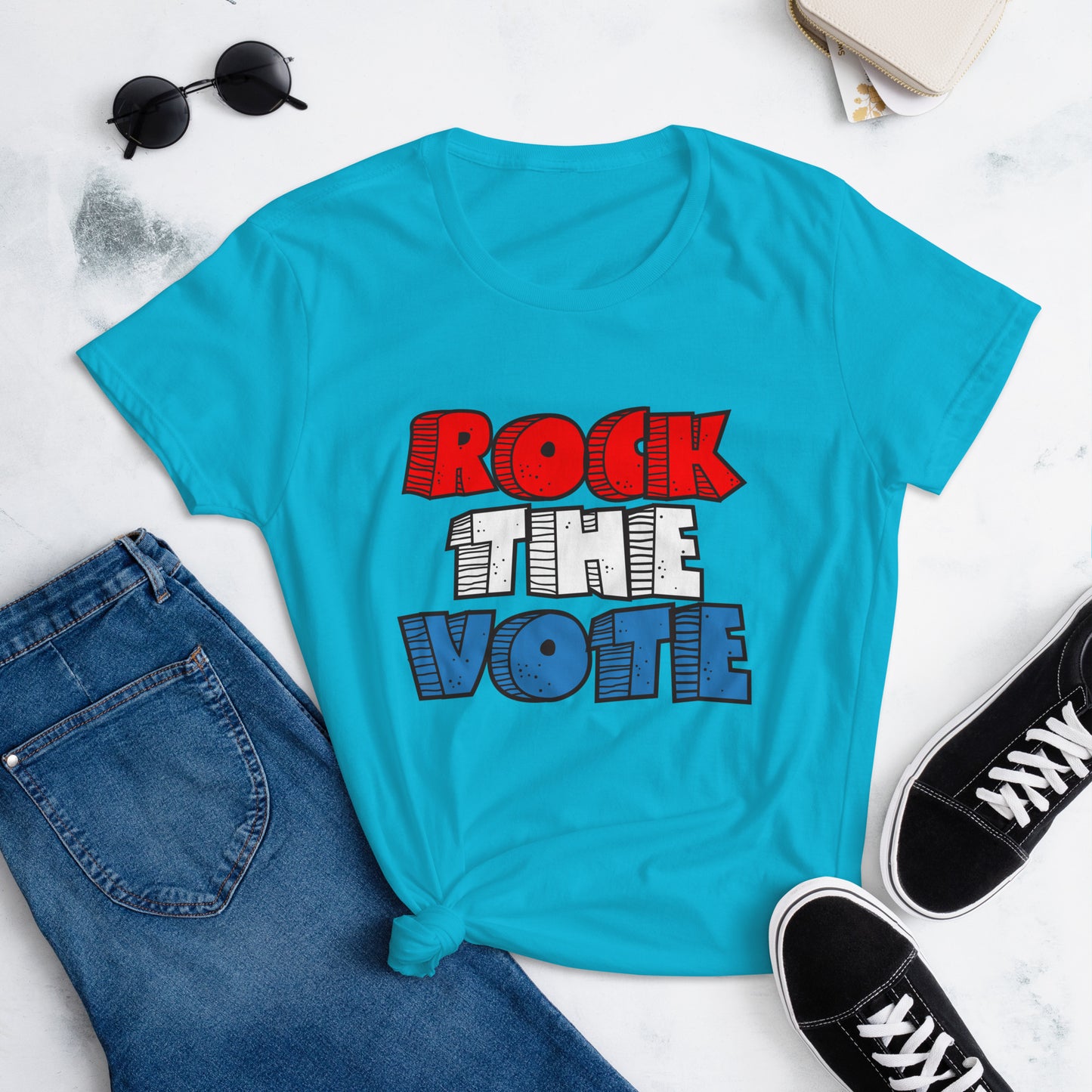 Rock The Vote T-Shirt with bold red, white, and blue lettering inspired by GenX style. The design features a retro, comic-style font with distressed detailing, representing a patriotic election theme. Available in unisex sizes and classic colors, perfect for showing civic pride and encouraging voter participation.