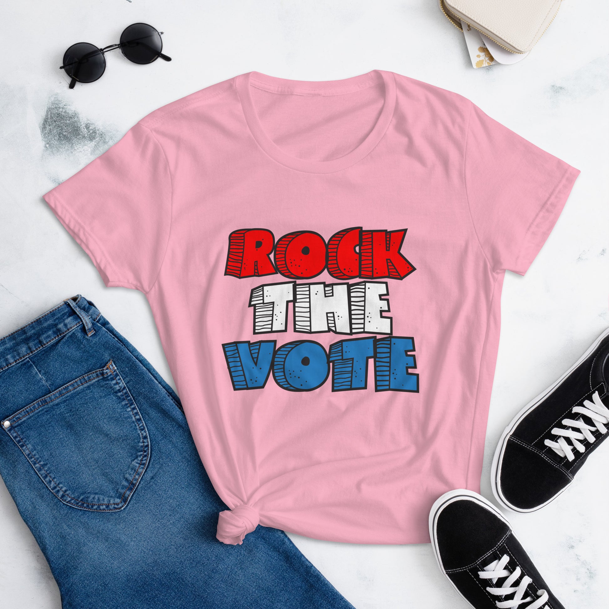 Rock The Vote T-Shirt with bold red, white, and blue lettering inspired by GenX style. The design features a retro, comic-style font with distressed detailing, representing a patriotic election theme. Available in unisex sizes and classic colors, perfect for showing civic pride and encouraging voter participation.