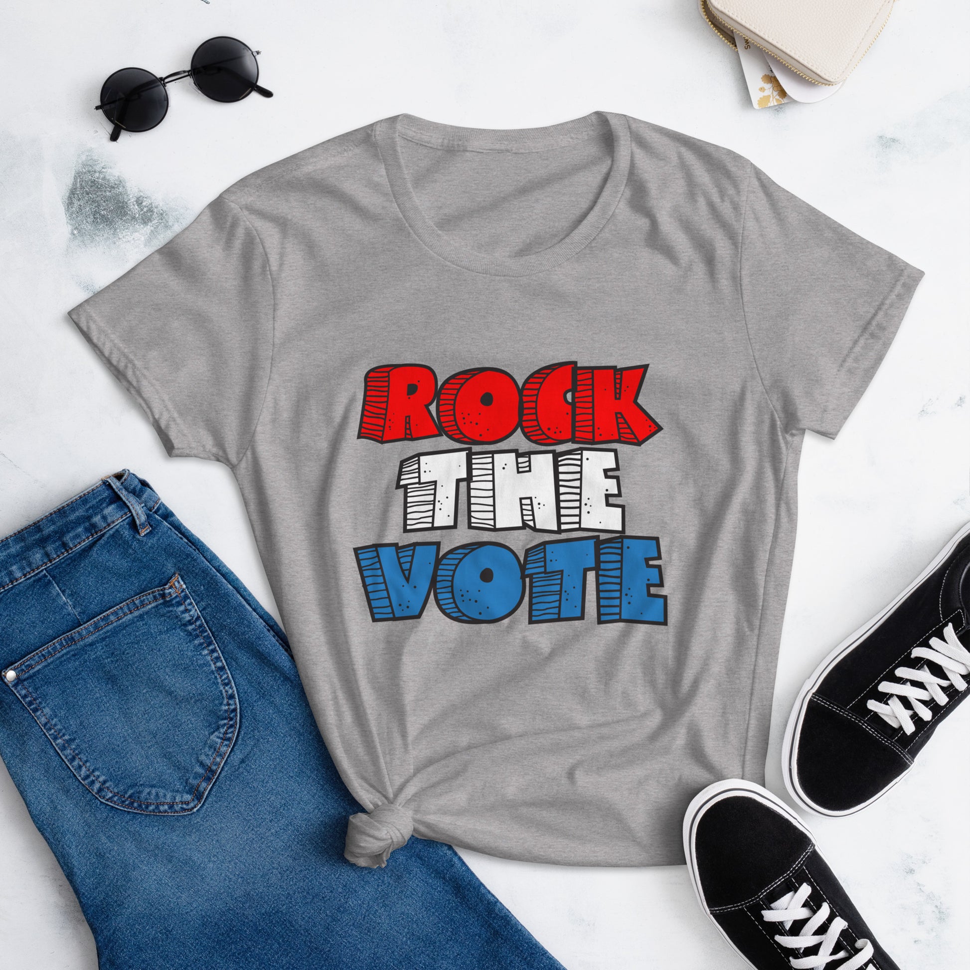 Rock The Vote T-Shirt with bold red, white, and blue lettering inspired by GenX style. The design features a retro, comic-style font with distressed detailing, representing a patriotic election theme. Available in unisex sizes and classic colors, perfect for showing civic pride and encouraging voter participation.