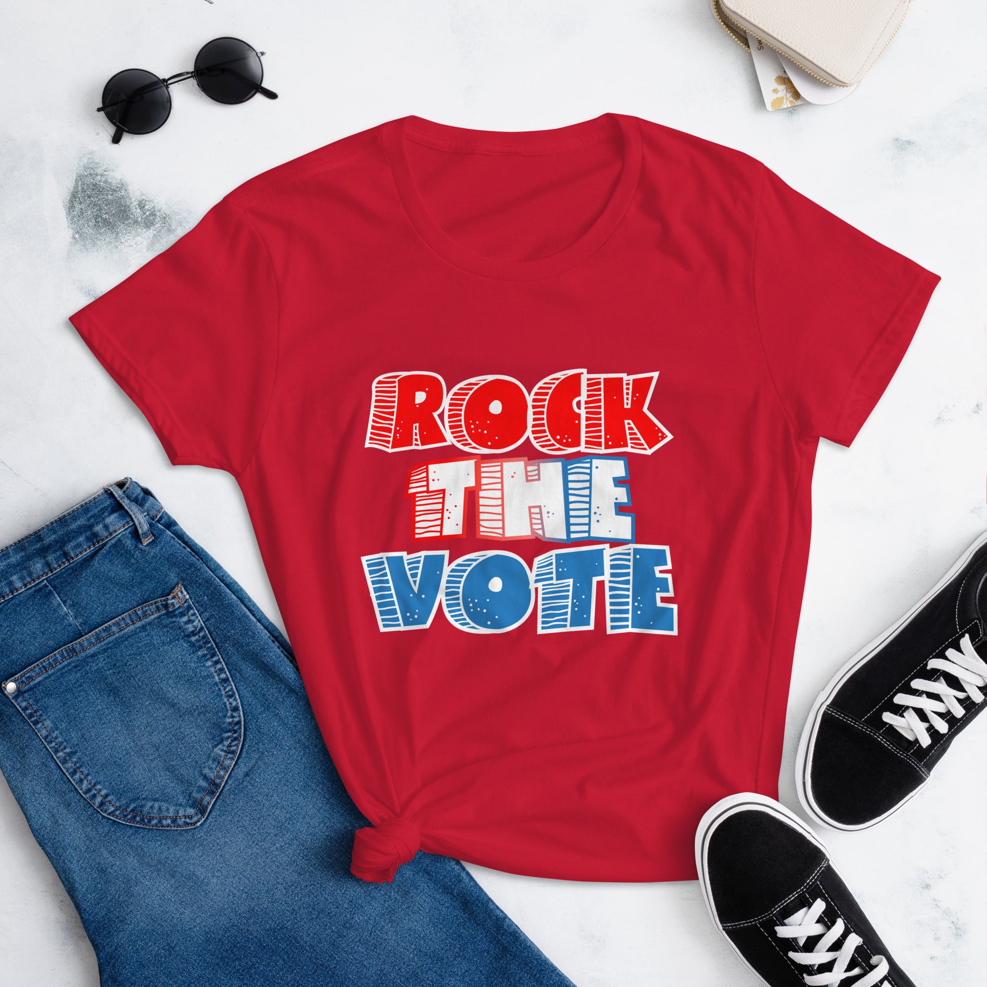 Rock The Vote T-Shirt with bold red, white, and blue lettering inspired by GenX style. The design features a retro, comic-style font with distressed detailing, representing a patriotic election theme. Available in unisex sizes and classic colors, perfect for showing civic pride and encouraging voter participation.